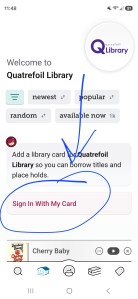 A screenshot of a smartphone screen open to the Libby app's page for the Quatrefoil Library. There is a pink rectangle that says "Sign In With My Card," which is circled and has an arrow pointing to it. 